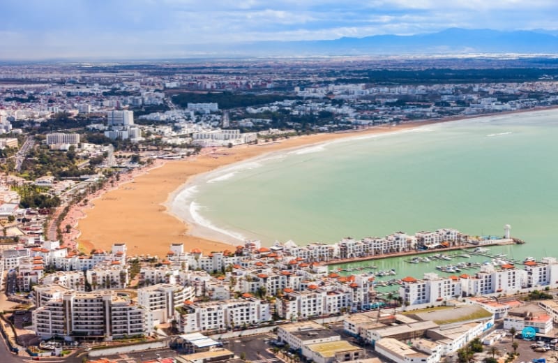 Panorama wybrzeża Agadiru z szeroką plażą i zabudową miasta przy spokojnym oceanie